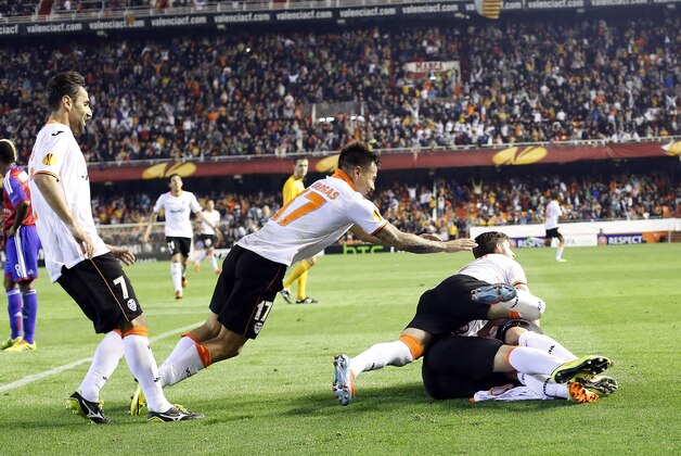 Valencia players celebrate Paco Alcacer scoring against Basel during the Europa League quarterfinal, second leg soccer match at the Mestalla stadium in Valencia, Spain, on Thursday, April 10, 2014. The game ended 5-0. Valencia qualified for the semifinal. (AP Photo/Alberto Saiz)