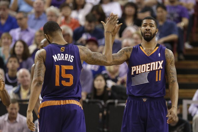Phoenix Suns forward Marcus Morris, left, congratulates his twin brother, Markieff, after he scored against the Sacramento Kings during the fourth quarter of an NBA basketball game in Sacramento, Calif., Wednesday, April 16, 2014. The Suns won 104-99.(AP Photo/Rich Pedroncelli)