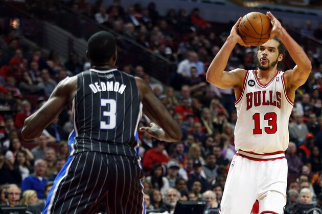 Chicago Bulls center Joakim Noah (13) shoots over Orlando Magic center Dewayne Dedmon (3) during the second half of an NBA basketball game Monday, April 14, 2014, in Chicago. The Bulls won the game 108-95.  (AP Photo/Jeff Haynes)