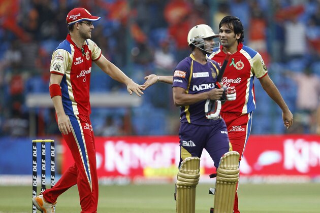Royal Challengers Bangalore Zaheer Khan, right, celebrates with captain Daniel Vettori, left, the dismissal of Kolkata Knight Riders batsman Manoj Tiwary, center, during their Indian Premier League (IPL) cricket match in Bangalore, India, Tuesday, April 10, 2012. (AP Photo/Aijaz Rahi)