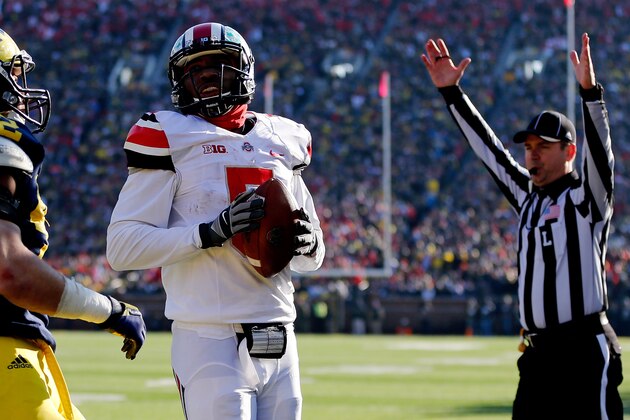 FILE - In this Nov. 30, 2013 file photo, Ohio State quarterback Braxton Miller (5) looks back at Michigan defensive back Blake Countess (18) as he rushes for a touchdown in the first quarter of an NCAA college football game in Ann Arbor, Mich. It seems as if No. 2 Ohio State has spent the past three months in a pressure-cooker. Now, after squeaking out its biggest win of the season against its bitter rival, the Buckeyes have to turn around and play yet another major showdown. They meet No. 10 Michigan State in the Big Ten championship game on Saturday.  (AP Photo/Tony Ding, File)