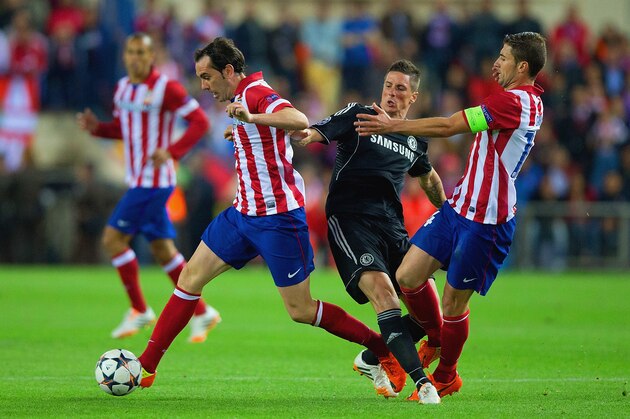 MADRID, SPAIN - APRIL 22:  Fernando Torres of Chelsea is closed down by and Diego Godin and Gabi of Club Atletico de Madrid during the UEFA Champions League Semi Final first leg match between Club Atletico de Madrid and Chelsea at Vicente Calderon Stadium on April 22, 2014 in Madrid, Spain.  (Photo by Gonzalo Arroyo Moreno/Getty Images)