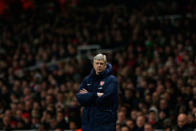Arsenal's French manager Arsene Wenger stands with his arms folded during the English Premier League soccer match between Arsenal and Swansea City at the Emirates Stadium in London, Tuesday, March 25, 2014.  (AP Photo/Matt Dunham)