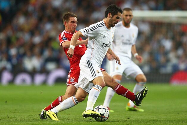 MADRID, SPAIN - APRIL 23: Philipp Lahm of Bayern Muenchen tackles Isco of Real Madrid during the UEFA Champions League semi-final first leg match between Real Madrid and FC Bayern Muenchen at the Estadio Santiago Bernabeu on April 23, 2014 in Madrid, Spain.  (Photo by Paul Gilham/Getty Images)