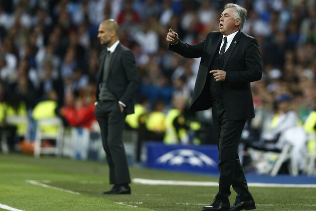Real's coach Carlo Ancelotti gestures to his players next to Bayern head coach Pep Guardiola, left, during a first leg semifinal Champions League soccer match between Real Madrid and Bayern Munich at the Santiago Bernabeu stadium in Madrid, Spain, Wednesday, April 23, 2014. (AP Photo/Andres Kudacki)