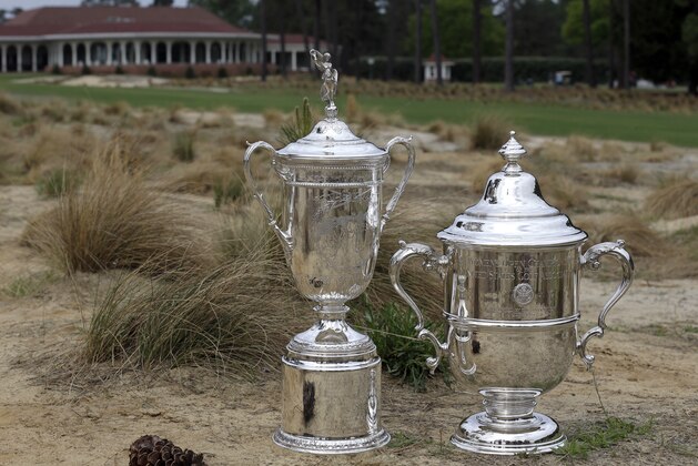 The men's and women's U.S. Open Championship trophies are shown along the 18th fairway at Pinehurst Resort & Country Club’s Course No. 2 in Pinehurst, N.C., Monday, April 14, 2014. The No. 2 course will host the 2014 U.S. Open Championship June 12-15 and the 2014 U.S. Women’s Open Championship June 19-22. (AP Photo/Gerry Broome)