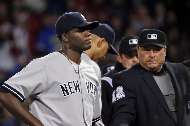 Home plate umpire Gerry Davis ejects New York Yankees starting pitcher Michael Pineda after a foreign substance was discovered on his neck in the second inning of the Yankees' baseball game against the Boston Red Sox at Fenway Park in Boston, Wednesday, April 23, 2014. (AP Photo/Elise Amendola)