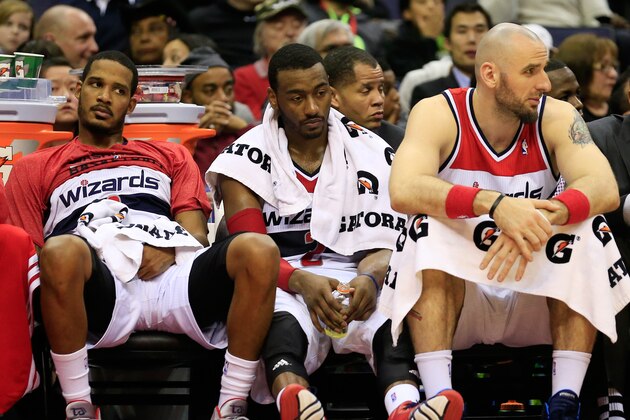 WASHINGTON, DC - DECEMBER 14: Trevor Ariza #1, (L) John Wall #2,  (C) and Marcin Gortat #4 (R) of the Washington Wizards watch the closing moments of the Wizards 113-97 loss to the Los Angeles Clippers at Verizon Center on December 14, 2013 in Washington, DC. NOTE TO USER: User expressly acknowledges and agrees that, by downloading and or using this photograph, User is consenting to the terms and conditions of the Getty Images License Agreement.  (Photo by Rob Carr/Getty Images)