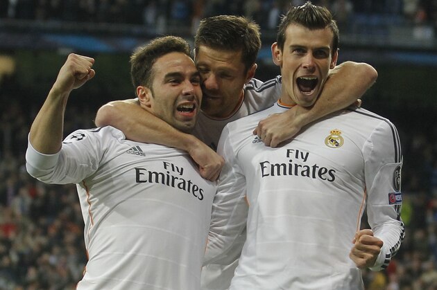 Real's Gareth Bale, right, celebrates scoring the opening goal with Real's Daniel Carvajal, left, and Xabi Alonso, center, during a Champions League quarterfinal first leg soccer match between Real Madrid and Borussia Dortmund at the Santiago Bernabeu   stadium in Madrid, Spain, Wednesday April 2, 2014. (AP Photo/Paul White)