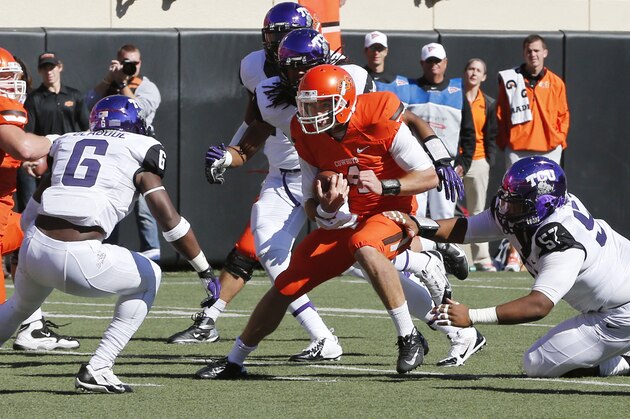 Oklahoma State quarterback J.W. Walsh, center, is stopped short of a touchdown by TCU defenders Elisha Olabode (6) and Davion Pierson (57) in the second quarter of an NCAA college football game in Stillwater, Okla., Saturday, Oct. 19, 2013. Oklahoma State won 24-10.(AP Photo/Sue Ogrocki)