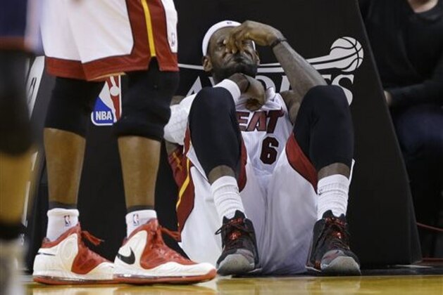 Miami Heat's LeBron James sits on the court after being elbowed by Charlotte Bobcats' Josh McRoberts during the second half in Game 2 of an opening-round NBA basketball playoff series, Wednesday, April 23, 2014, in Miami. The Heat defeated the Bobcats 101-97. (AP Photo/Lynne Sladky)