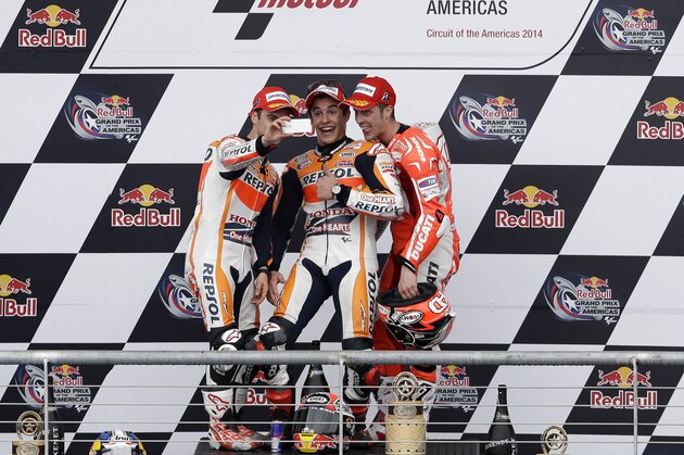 Dani Pedrosa, from left, of Spain, Marc Marquez of Spain, and Andrea Dovizioso, right, of Italy shoot a selfie of themselves on the winners podium following the Grand Prix of the Americas MotoGP motorcycle race, Sunday, April 13, 2014, in Austin, Texas. Marquez won the race, with Pedrosa  and Dovizioso in second and third respectively. (AP Photo/Tony Gutierrez)