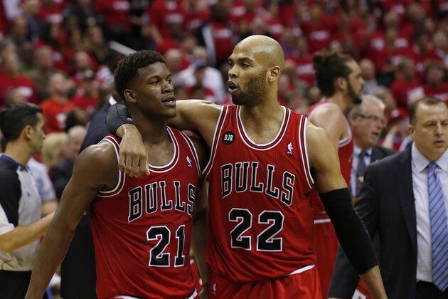 Chicago Bulls guard Jimmy Butler (21) is pulled away by forward Taj Gibson (22) after an altercation with Washington Wizards forward Nene (42), from Brazil, in the second half of Game 3 of an opening-round NBA basketball playoff series on Friday, April 25, 2014, in Washington. Nene received a double technical and was ejected. The Bulls won 100-97. (AP Photo/Alex Brandon)