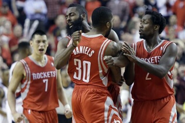 CORRECTS PERIOD TO OVERTIME - Houston Rockets guard Troy Daniel, middle, celebrates with teammates James Harden, left, and Patrick Beverley after sinking a three point shot in overtime to take the lead during Game 3 of an NBA basketball first-round playoff series against the Portland Trail Blazers in Portland, Ore., Friday, April 25, 2014.  The Rockets won 121-116. (AP Photo/Don Ryan)