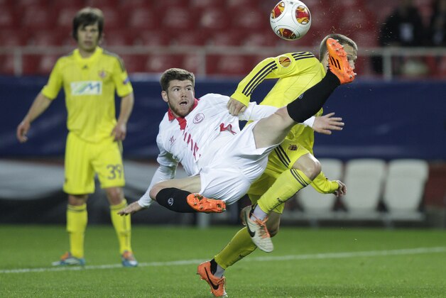 Sevilla's Alberto Moreno, center, and Maribor's Dejan Mezga, right, challenge for the ball during their Europa League round of 32 second leg soccer match at the Ramon Sanchez Pizjuan stadium in Seville, Spain Thursday, Feb. 27, 2014. (AP Photo/Toni Rodriguez)