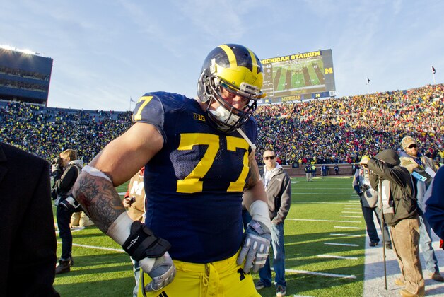 Michigan offensive lineman Taylor Lewan (77) walks off the field in dejection after an NCAA college football game against Ohio State in Ann Arbor, Mich., Saturday, Nov. 30, 2013. Ohio State won 42-41. (AP Photo/Tony Ding)