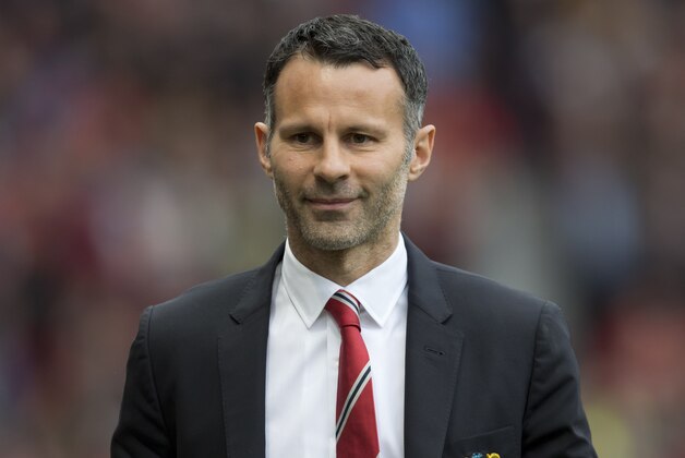 Manchester United's interim manager Ryan Giggs smiles as he takes to the touchline before his team's English Premier League soccer match against Norwich City at Old Trafford Stadium, Manchester, England, Saturday April 26, 2014. (AP Photo/Jon Super)