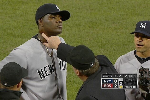 In this April 23, 2014 photo taken from video and provided by ESPN, home plate umpire Gerry Davis touches the neck of New York Yankees starting pitcher Michael Pineda in the second inning of the Yankees' baseball game against the Boston Red Sox at Fenway Park in Boston. Pineda was ejected after umpires found a foreign substance on his neck. (AP Photo/ESPN)