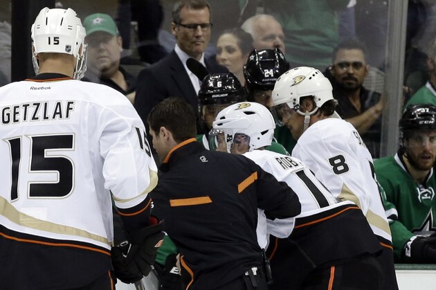 Anaheim Ducks' Ryan Getzlaf watches as Stephane Robidas, third from left, is helped off the ice by a staff member and Teemu Selanne (8) after suffering an unknown in injury in the second period of Game 3 of a first-round NHL hockey Stanley Cup playoff series game against the Dallas Stars, Monday, April 21, 2014, in Dallas. (AP Photo/Tony Gutierrez)