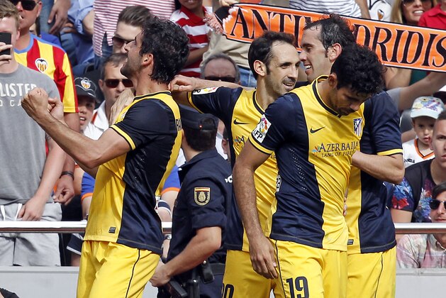 Atletico's de Madrid Raul Garcia Capitan, left, celebrates after scoring against Valencia during a Spanish La Liga soccer match at the Mestalla stadium in Valencia, Spain, on Sunday, April 27, 2014. (AP Photo/Alberto Saiz)