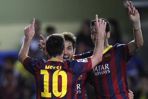 Barcelona's  Lionel Messia, left, and Cesc Fabregas, center, celebrates after their team scored a goal during a Spanish La Liga soccer match at the Madrigal stadium in Villarreal, Spain, on Sunday, April 27, 2014. (AP Photo/Alberto Saiz)