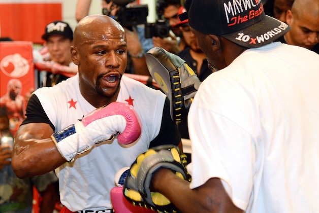 LAS VEGAS, NV - APRIL 22:  Boxer Floyd Mayweather Jr. (L) works out with his trainer and uncle Roger Mayweather at the Mayweather Boxing Club on April 22, 2014 in Las Vegas, Nevada. Mayweather will face Marcos Maidana in a 12-round world championship unification bout in Las Vegas on May 3.  (Photo by Ethan Miller/Getty Images)