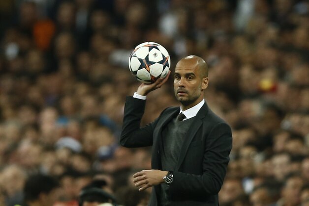Bayern head coach Pep Guardiola, holds the ball during a first leg semifinal Champions League soccer match between Real Madrid and Bayern Munich at the Santiago Bernabeu stadium in Madrid, Spain, Wednesday, April 23, 2014. (AP Photo/Andres Kudacki)