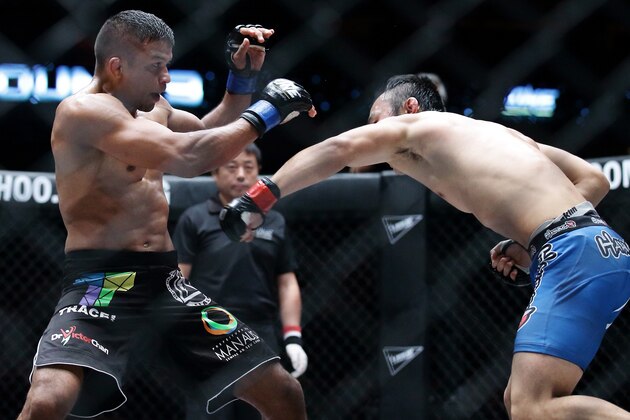 SINGAPORE - OCTOBER 18:  Soo Chul Kim (R) of South Korea throws a punch at  Bibiano Fernandes of Brazil during the One Fighting Championship Bantamweight World Championship Unification bout at Singapore Indoor Stadium on October 18, 2013 in Singapore.  (Photo by Suhaimi Abdullah/Getty Images)