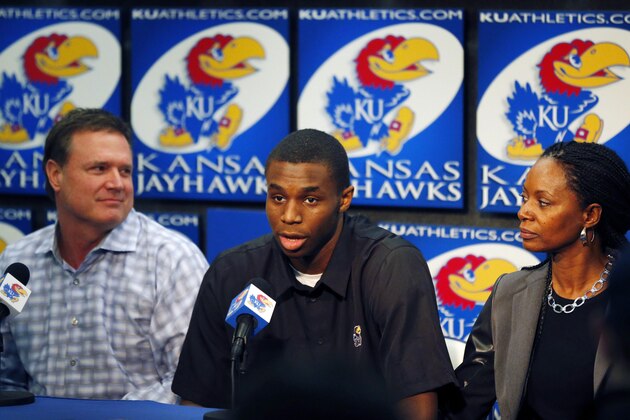 Kansas NCAA college freshman basketball player Andrew Wiggins, middle, speaks between coach Bill Self, left, and his mother Marita Payne-Wiggins, right, during a news conference at the University of Kansas in Lawrence, Kan., Monday, March 31, 2014. Wiggins announced he would be entering the NBA draft. (AP Photo/Orlin Wagner)