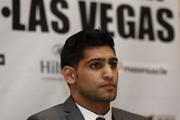 British Boxer Amir Khan poses for the photographers following a news conference in London, Tuesday, March 13, 2012. Light Welterweight World Champion US boxer Lamont Peterson will defends his WBA and IBF light-welterweight titles against British challenger Khan in a rematch of their disputed fight last year on May 19, 2012  Las Vegas. Khan lost both belts in a split-decision loss to the American on Dec. 10. But he complained about the referee's decision to deduct two points for pushing and the presence of an unauthorized man at ringside seen distracting an official. (AP Photo/Lefteris Pitarakis)
