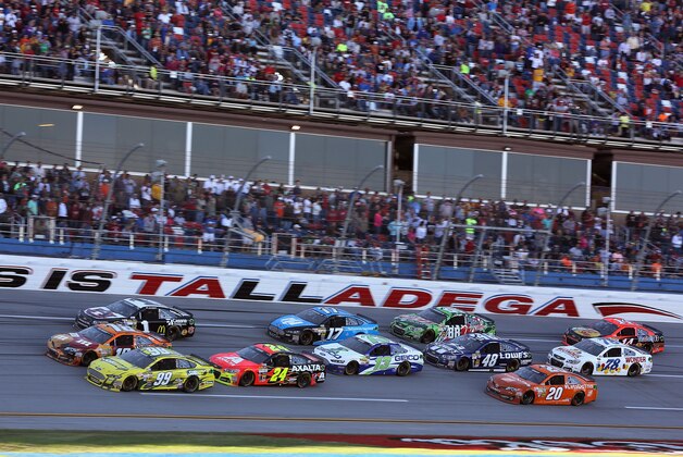 Sprint Cup Series driver Denny Hamlin (11) leads a pack of cars through the tri-oval during the NASCAR Sprint Cup Series auto race at the Talladega Superspeedway in Talladega, Ala., Sunday, Oct. 20, 2013. (AP Photo/Jay Sailors)
