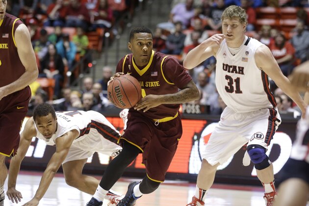 Arizona State's Jahii Carson (1) drives between Utah's Brandon Taylor, left, and Dallin Bachynski (31) in the first half of an NCAA college basketball game Sunday, Feb. 23, 2014, in Salt Lake City. (AP Photo/Rick Bowmer)