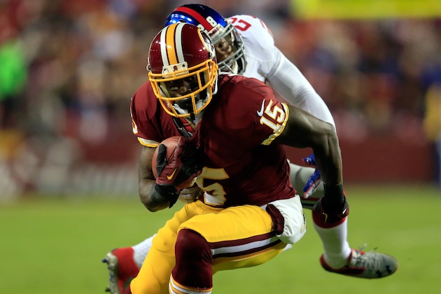 LANDOVER, MD - DECEMBER 01:  Josh Morgan #15 of the Washington Redskins runs the ball against Jayron Hosley #28 of the New York Giants in the first quarter during their game at FedExField on December 1, 2013 in Landover, Maryland.  (Photo by Rob Carr/Getty Images)