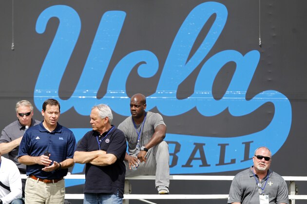 UCLA head coach Jim Mora, left, talks with an NFL scout from the Nashville Titans during UCLA pro day at Spaulding Field on Tuesday, March 11, 2014, in Los Angeles.  (AP Photo/Alex Gallardo)