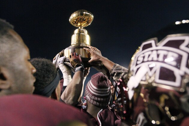 Mississippi State football players celebrate as they carry the Egg Bowl trophy after they defeated Mississippi 17-10 in overtime in an NCAA college football game, Thursday, Nov. 28, 2013, in Starkville, Miss. (AP Photo/Rogelio V. Solis)