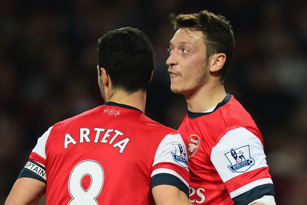 LONDON, ENGLAND - APRIL 28:  Mesut Oezil of Arsenal (11) celebrates with Mikel Arteta as he scores their second goal during the Barclays Premier League match between Arsenal and Newcastle United at Emirates Stadium on April 28, 2014 in London, England.  (Photo by Jamie McDonald/Getty Images)