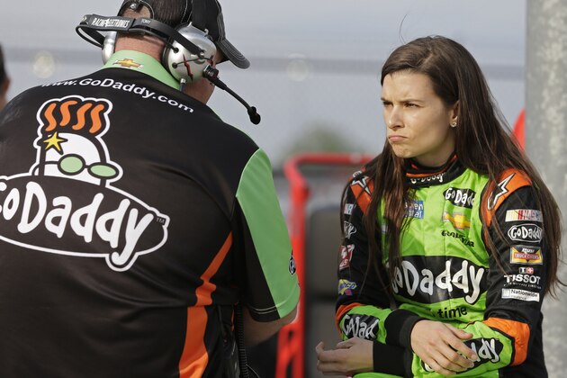 Danica Patrick, right, talks to a crew member before qualifying for a NASCAR Sprint Cup series auto race at Darlington Speedway in Darlington, S.C., Friday, April 11, 2014. (AP Photo/Chuck Burton)