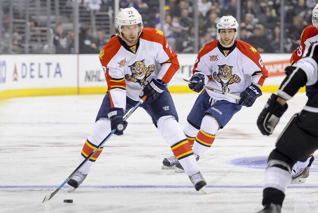 Florida Panthers defenseman Tom Gilbert (77) and teammate center Vincent Trocheck (67) bring the puck up the ice during the first period of an NHL hockey game against the Los Angeles Kings, Saturday, March 22, 2014, in Los Angeles. (AP Photo/Gus Ruelas)