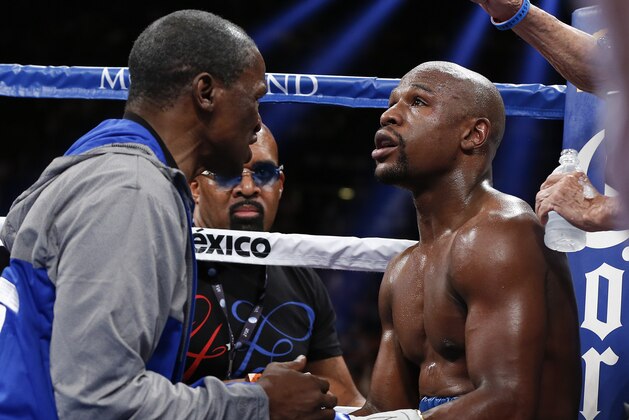 Floyd Mayweather Jr., right, listens to his father and coach Floyd Mayweather between rounds against Canelo Alvarez during a 152-pound title fight, Saturday, Sept. 14, 2013, in Las Vegas. (AP Photo/Eric Jamison)