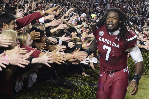 South Carolina defensive end Jadeveon Clowney (7) celebrates with fans after defeating Clemson 31-17 in an NCAA college football game on Saturday, Nov. 30, 2013, in Columbia, S.C. (AP Photo/Richard Shiro)