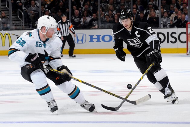 LOS ANGELES, CA - APRIL 28:  Dustin Brown #23 of the Los Angeles Kings skates with the puck against Matt Irwin #52 of the San Jose Sharks in Game Six of the First Round of the 2014 Stanley Cup Playoffs at Staples Center on April 28, 2014 in Los Angeles, California. (Photo by Noah Graham/NHLI via Getty Images)