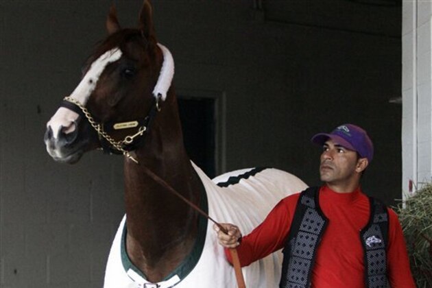 Exercise rider William Delgado holds Kentucky Derby hopeful California Chrome after a morning workout at Churchill Downs Tuesday, April 29, 2014, in Louisville, Ky. (AP Photo/Garry Jones)