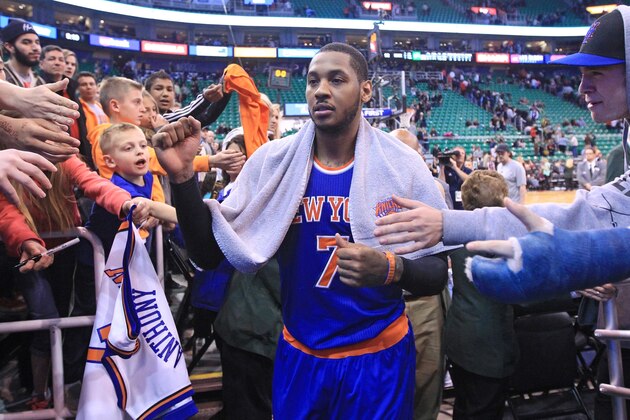 Fans reach for New York Knicks' Carmelo Anthony (7) as he walks off the court following their NBA basketball game against the Utah Jazz Monday, March 31, 2014, in Salt Lake City. The Knicks won 92-83. (AP Photo/Rick Bowmer)