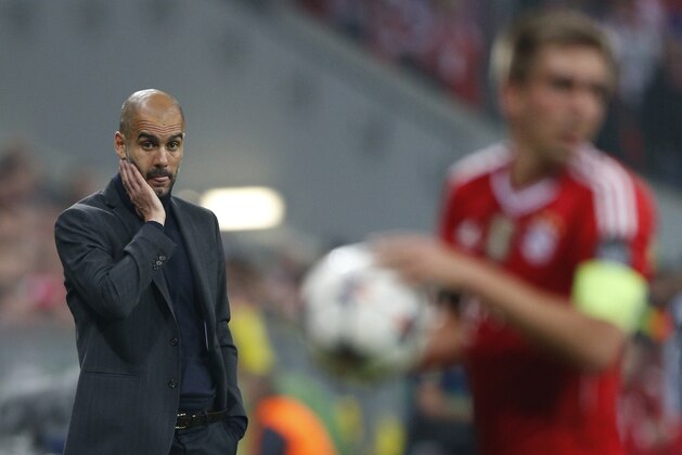 Bayern head coach Pep Guardiola, left, looks to team captain Philipp Lahm during the Champions League semifinal second leg soccer match between Bayern Munich and Real Madrid at the Allianz Arena in Munich, southern Germany, Tuesday, April 29, 2014. (AP Photo/Matthias Schrader)
