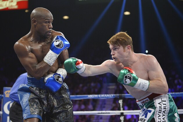 Canelo Alvarez, right, throws a jab at Floyd Mayweather Jr. in the second round during a 152-pound title fight, Saturday, Sept. 14, 2013, in Las Vegas. (AP Photo/Mark J. Terrill)