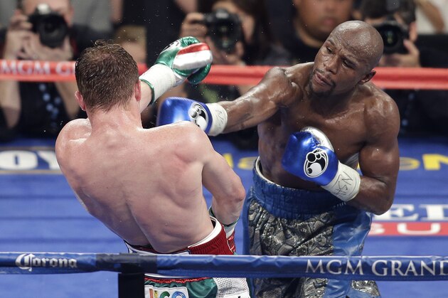 Floyd Mayweather Jr. throws a punch against Canelo Alvarez during a 152-pound title fight, Saturday, Sept. 14, 2013, in Las Vegas. (AP Photo/Isaac Brekken)