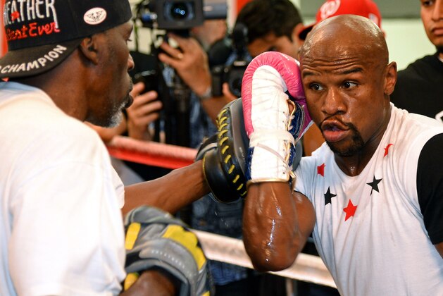 LAS VEGAS, NV - APRIL 22:  Boxer Floyd Mayweather Jr. (R) works out with his trainer and uncle Roger Mayweather at the Mayweather Boxing Club on April 22, 2014 in Las Vegas, Nevada. Mayweather will face Marcos Maidana in a 12-round world championship unification bout in Las Vegas on May 3.  (Photo by Ethan Miller/Getty Images)