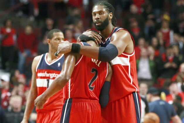Washington Wizards forward Nene Hilario, right, hugs guard John Wall in the closing seconds of the second half of Game 5 in an opening-round NBA basketball playoff series against the Chicago Bulls, Tuesday, April 29, 2014, in Chicago. The Wizards eliminated the Bulls winning 75-69. (AP Photo/Charles Rex Arbogast)