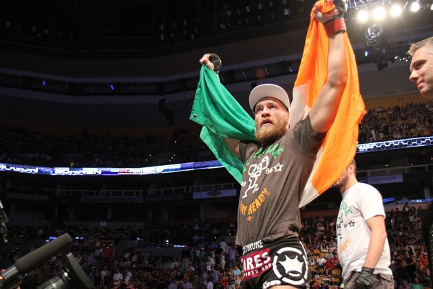 Conor McGregor, of Ireland, leaves the ring draped in an Irish flag after beathing Max Holloway in their UFC on Fox Sports 1 mixed martial arts bout in Boston, Saturday, August 17,2013. McGregor won via unanimous decision. (AP Photo/Gregory Payan)