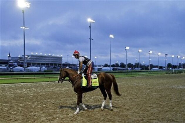 Exercise rider William Delgado takes Kentucky Derby hopeful California Chrome for a morning workout at Churchill Downs Wednesday, April 30, 2014, in Louisville, Ky. (AP Photo/Garry Jones)
